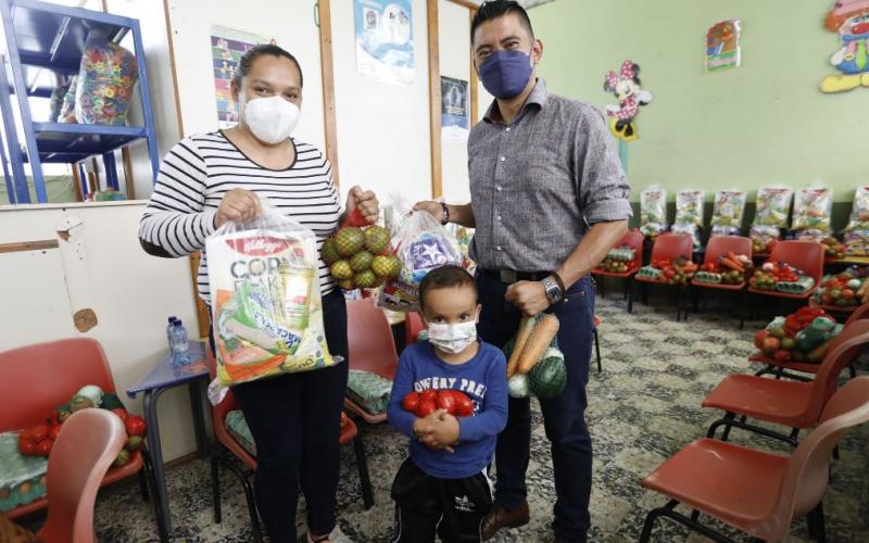 En el CADI de Palencia, uno de los niños beneficiarios recibe junto a su mamá la bolsa de aliementos
