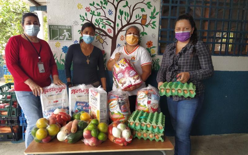 Padres de familia reciben alimentos para sus hijos.