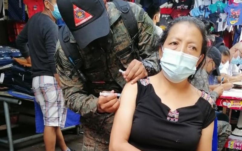Los soldados en conjunto con el personal de salud, recorren los locales de este mercado para aplicar la vacuna a los locatarios.