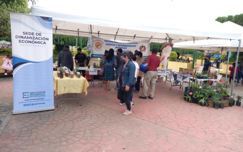 Personas caminan frente a feria de emprendimiento