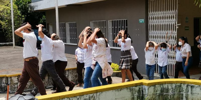 Estudiantes del Centro de Estudio Nueva Familia evacúan las instalaciones, como parte del simulacro desarrollado en la capacitación.