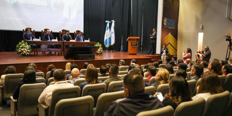 Invitados presentes escuchan la presentación del lanzamiento de las becas para enfermería por parte del Ministerio de Economía. 